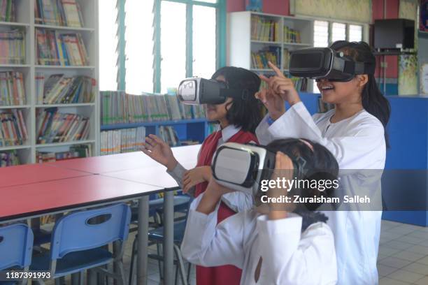 asian school girls use virtual reality goggles in the classroom at school - virtual reality classroom stock pictures, royalty-free photos & images