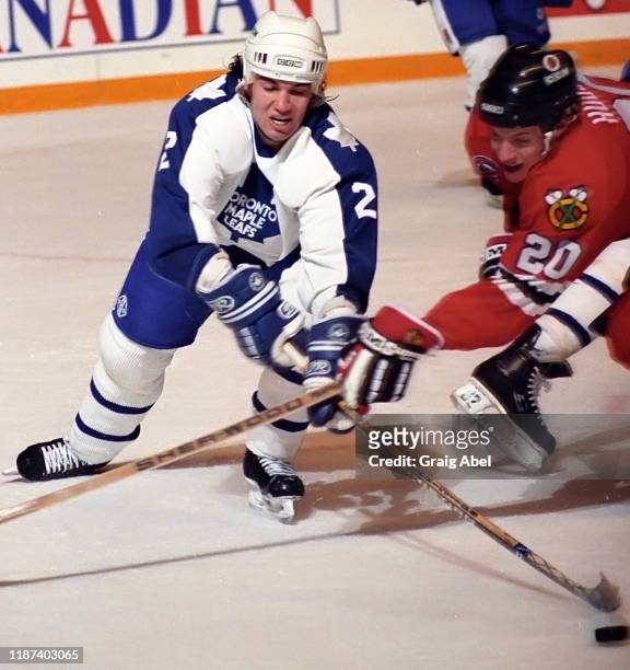 Luke Richardson of the Toronto Maple Leafs skates against Mike Hudson of the Chicago Blackhawks during NHL game action on December 8, 1990 at Maple...