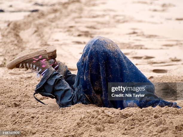 child digging hole in sand at beach - nascondere la testa nella sabbia foto e immagini stock