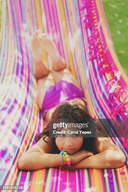 girl with big hat resting in hammock - girls sunbathing stock-fotos und bilder