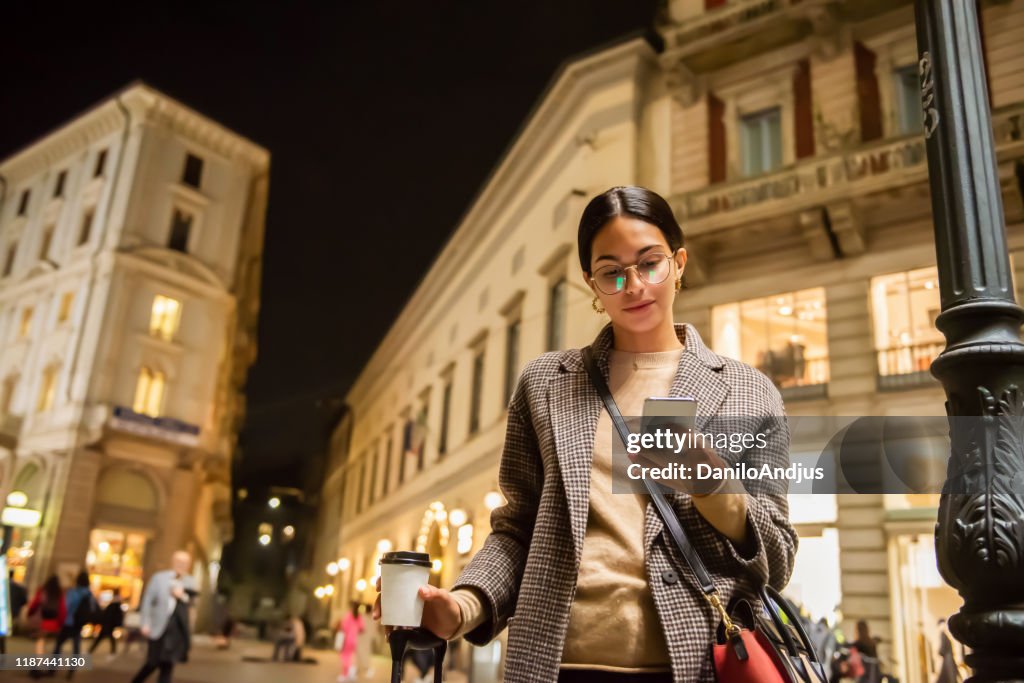 Young woman with suitcase enjoying in her coffee during a business travel