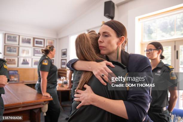 New Zealand's Prime Minister Jacinda Ardern hugs a first responder from the St John's ambulance team that helped those injured in the White Island...