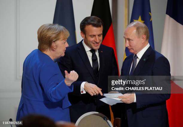 German Chancellor Angela Merkel, French President Emmanuel Macron and Russia's President Vladimir Putin speak during a press conference after a...