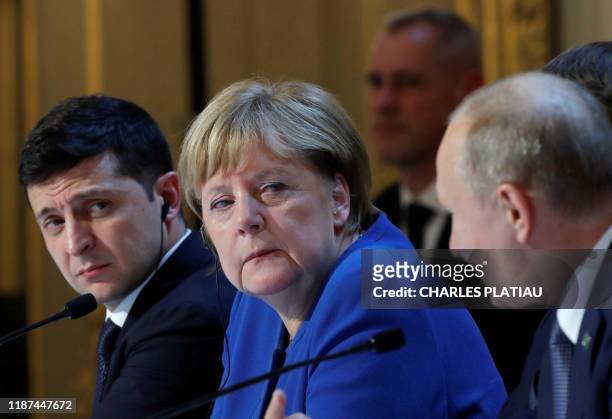 Ukraine's President Volodymyr Zelenskiy and German Chancellor Angela Merkel listen to Russia's President Vladimir Putin as they attend a press...