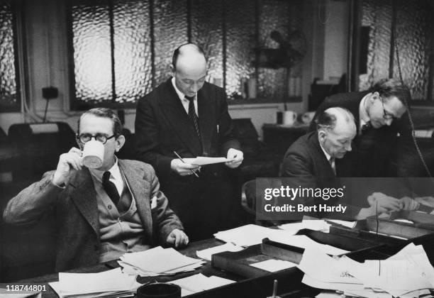 The 'copy-taster' selects material, while Editor Arthur Waters decides on the treatment of a story with a member of his staff, on a Saturday...