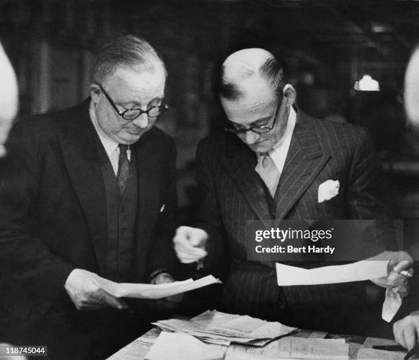 The chief printer consults with the works manager on a Saturday afternoon at the offices of the News of The World, April 1953. Original Publication :...