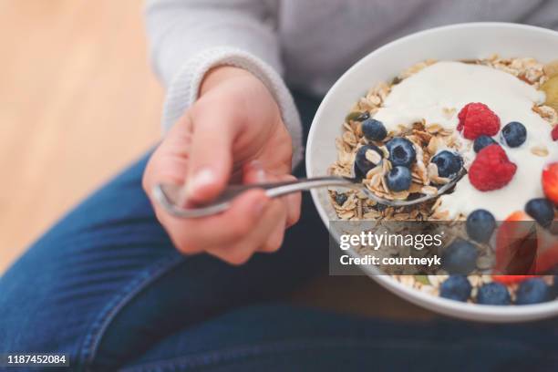 vrouw eten gezond ontbijt bowl. - bowl of blueberries stockfoto's en -beelden