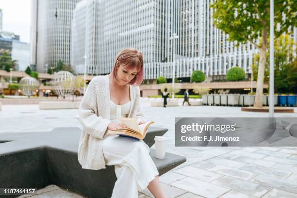 modern woman reading book in business area - j lee fotografías e imágenes de stock