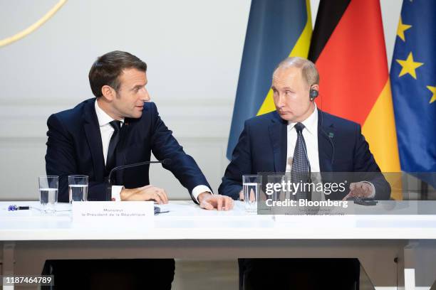 Emmanuel Macron, France's president, left, speaks beside Vladimir Putin, Russia's president, during a news conference following a 4-way summit on...