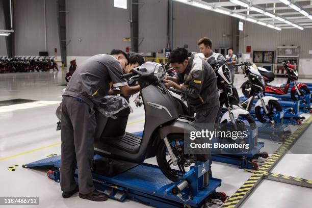 Workers inspect a Vinfast Klara electric scooter at the automaker's factory in Haiphong, Vietnam, on Wednesday, Dec. 4, 2019. Vingroup JSC Chairman...