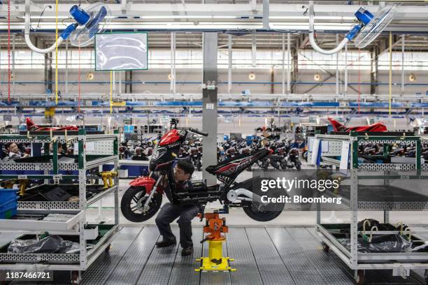 Workers labors on a Vinfast Impes electric scooter on the assembly line at the automaker's factory in Haiphong, Vietnam, on Wednesday, Dec. 4, 2019....
