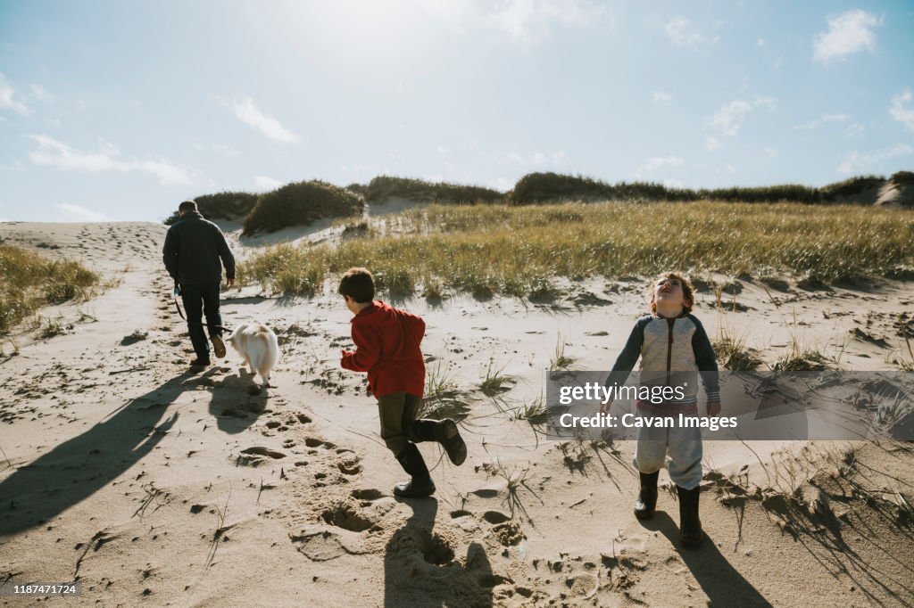 Family with dog on sand dune