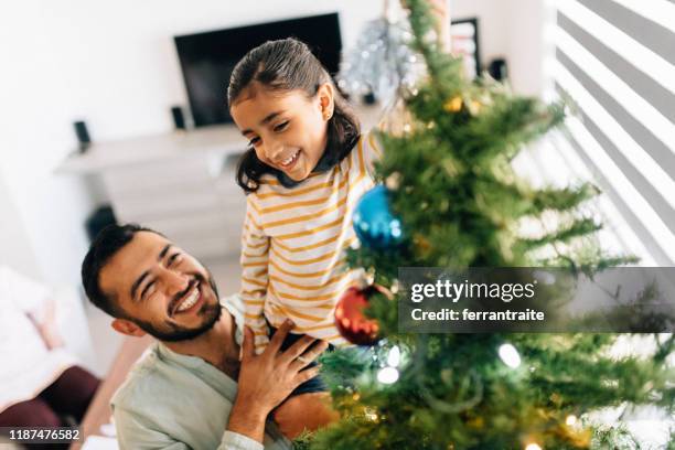 father and daughter decorating christmas tree - mexican christmas stock pictures, royalty-free photos & images