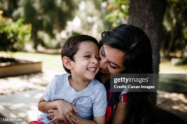 mother & autistic son laughing & hugging - autistic child stock pictures, royalty-free photos & images