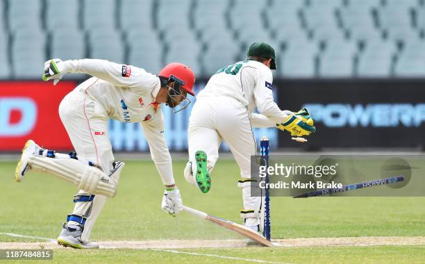 Jake Lehmann of the Redbacks nearly run out as Tim Paine of Tasmania knocks out the stumps during day four of the Sheffield Shield match between...