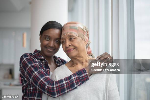 daughter hugging her mother with cancer stock photo - african american grandmother stock pictures, royalty-free photos & images