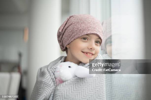 little girl with cancer wrapped in a blanket stock photo - childhood cancer stock pictures, royalty-free photos & images