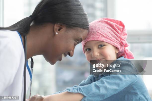 little girl with cancer visits the doctor stock photo - childhood cancer stock pictures, royalty-free photos & images