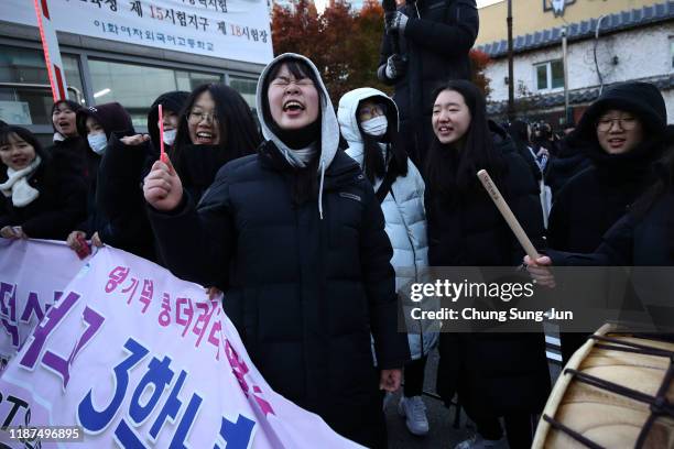 South Korean high school girls cheer for their senior classmates taking the College Scholastic Ability Test on November 14, 2019 in Seoul, South...