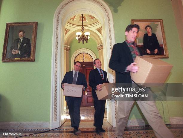 Congressional aids carry boxes of impeachment documents from the US House to the US Senate 13 January on Captiol Hill in Washington, DC. Opening...