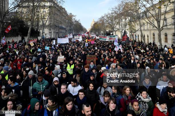 Demonstrators march in Paris, on December 10, 2019 on a sixth day of a strike over French government's plan to overhaul the country's retirement...
