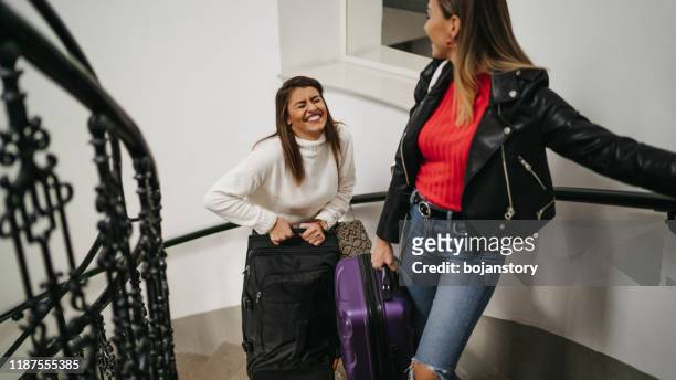 cheerful roommate with suitcases on staircase - college visit stock pictures, royalty-free photos & images