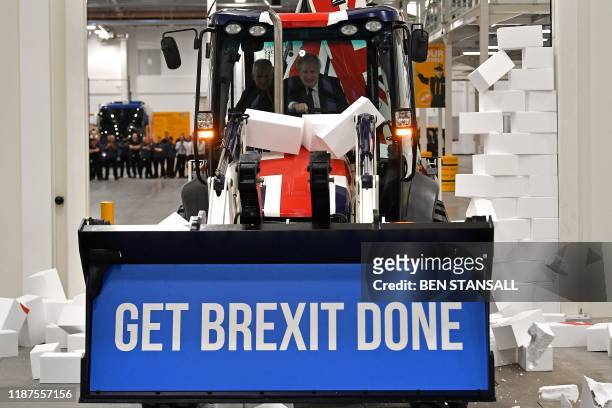 Britain's Prime Minister and Conservative party leader Boris Johnson drives a Union flag-themed JCB, with the words "Get Brexit Done" inside the...