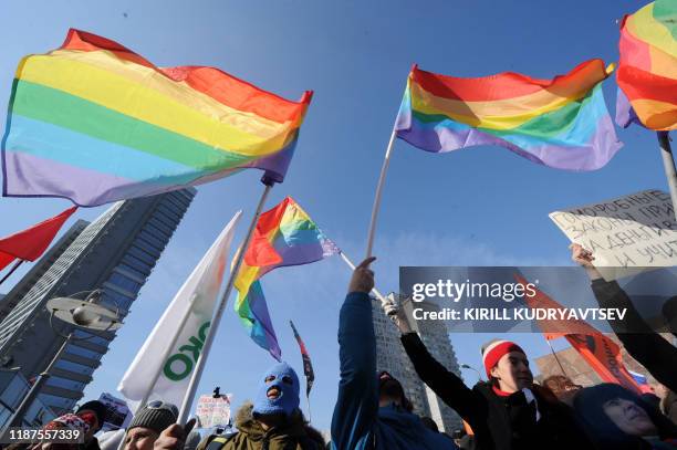 Gay rights activists take part in an anti-Putin rally in the central Arbat area in Moscow, on March 10, 2012. The partly seen makeshift poster...