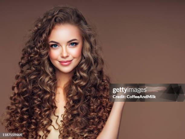 ボリュームのある巻き毛の髪型を持つ美しい女性 - hair products ストックフォトと画像