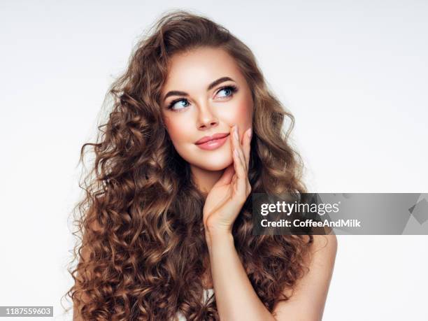 young woman with brown voluminous and curly hair - shiny wavy hair stock pictures, royalty-free photos & images