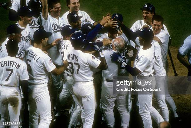 Kirk Gibson of the Los Angeles Dodgers is mobbed by teammates after he hit a pitch hit home run in the bottom of the 9th inning off of relief pitcher...