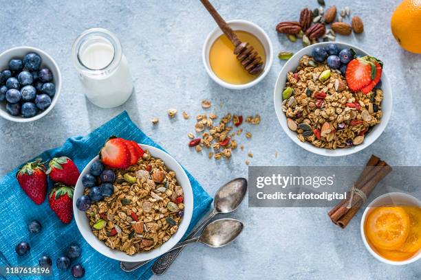 alimentación saludable: dos cuencos de granola con frutas para el desayuno. vista superior - blue bowl fotografías e imágenes de stock