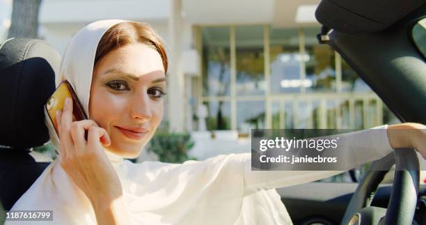 mujer islámica usando el teléfono inteligente en el coche - hot arabian women fotografías e imágenes de stock