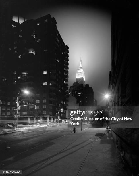 Nighttime view looking west on East 35th Street past Lexington Avenue with the Empire State Building in the distance, New York, New York, circa 1975.