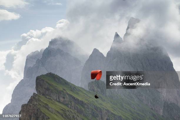 schilderachtig uitzicht op paraglider vliegen door mountain valley - paragliding stockfoto's en -beelden