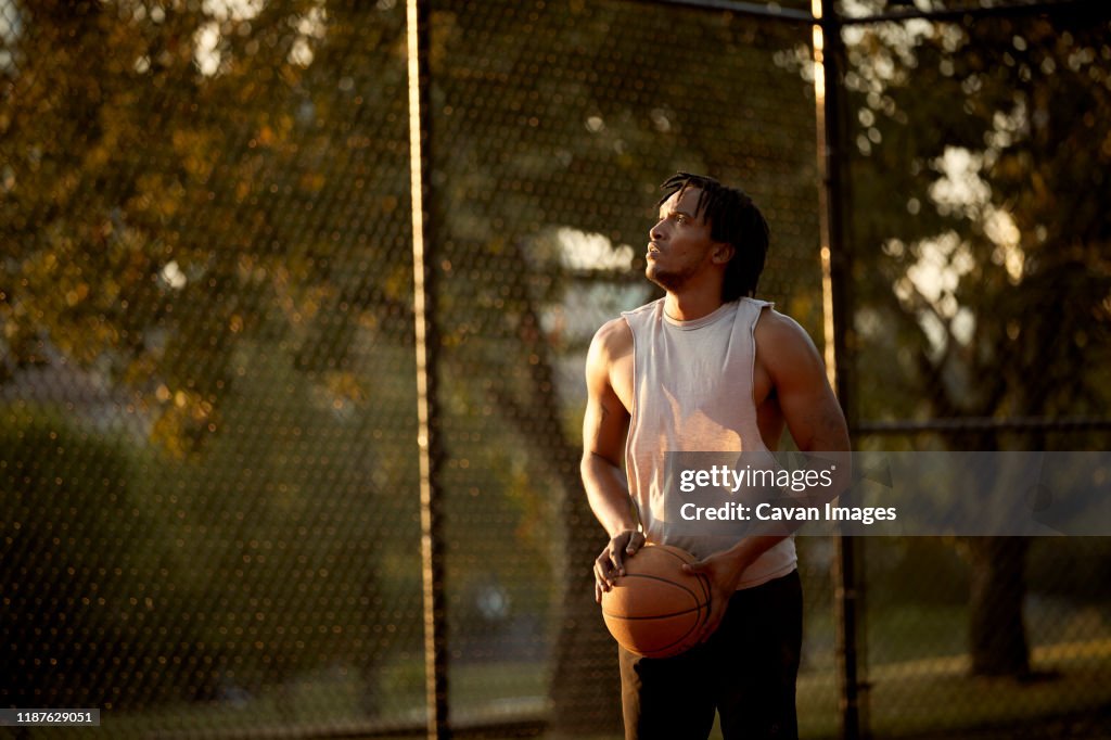 African-American man playing basketball outdoors