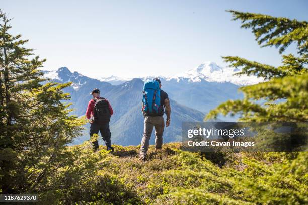 two backpackers hiking on bald mountain, washington. - mt baker stockfoto's en -beelden