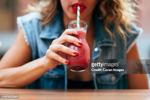 pretty woman red lips drinking a cocktail soda - daiquiri stock pictures, royalty-free photos & images