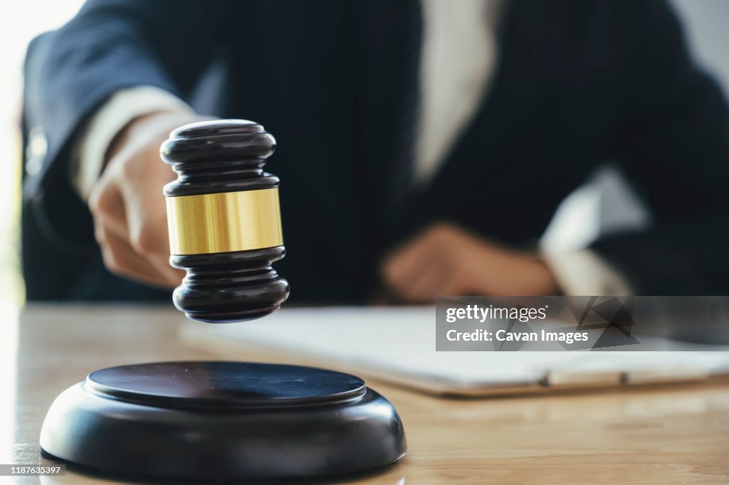 Male lawyer in the office with brass scale._x000D_