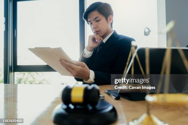 male lawyer in the office with brass scale._x000d_ - prosecuting attorney stock pictures, royalty-free photos & images