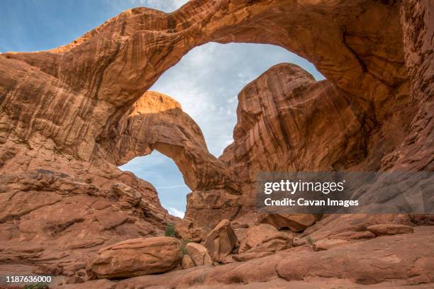 sunset at double arch in arches national park, utah. - southern utah stock pictures, royalty-free photos & images