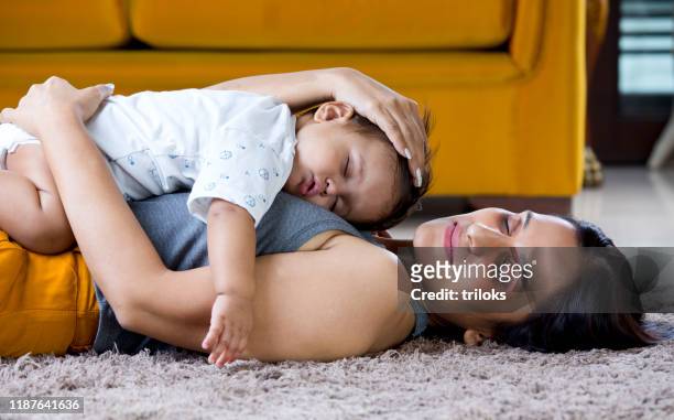 baby boy sleeping on top of mother at home - indian baby boy stock pictures, royalty-free photos & images