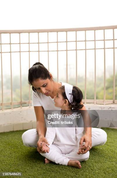 mother with daughter meditating in lotus position - indian tour guide stock pictures, royalty-free photos & images