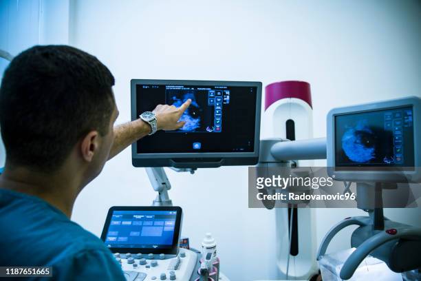 medico che esamina i seni con mammografia - seno foto e immagini stock
