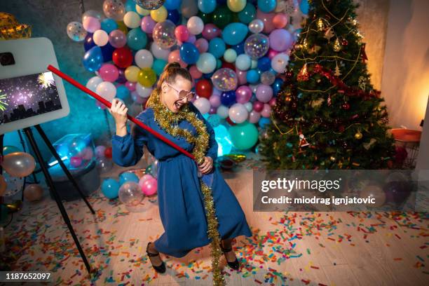 funny woman having good time while cleaning after party - christmas photo booth stock pictures, royalty-free photos & images