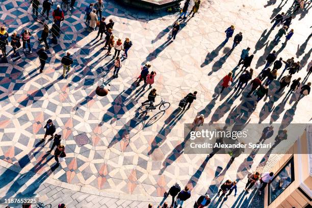crowd of people walking on a city square at sunset - scandinavie photos et images de collection