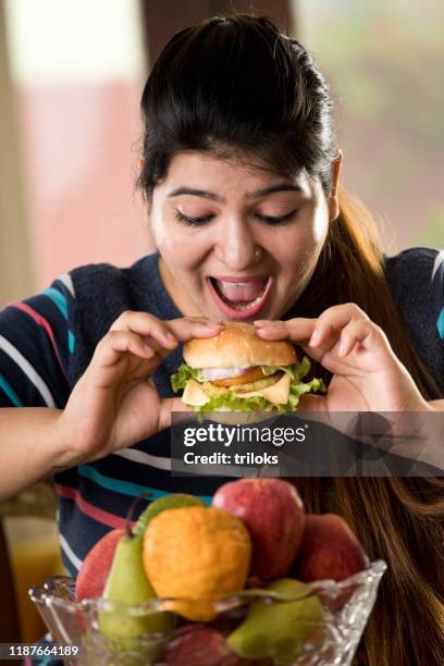 frau isst einen fast-food-burger - fat woman stock-fotos und bilder