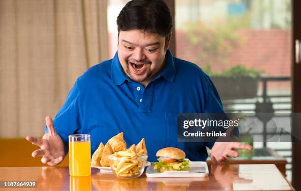 excited fat man with plate of samosa - unhealthy eating stock pictures, royalty-free photos & images