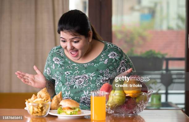 astonished woman looking at unhealthy food - samosa stock pictures, royalty-free photos & images