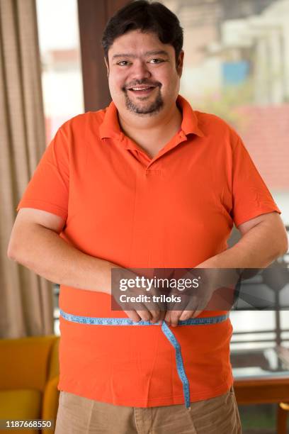 obese man measuring his belly - tape measure stock pictures, royalty-free photos & images
